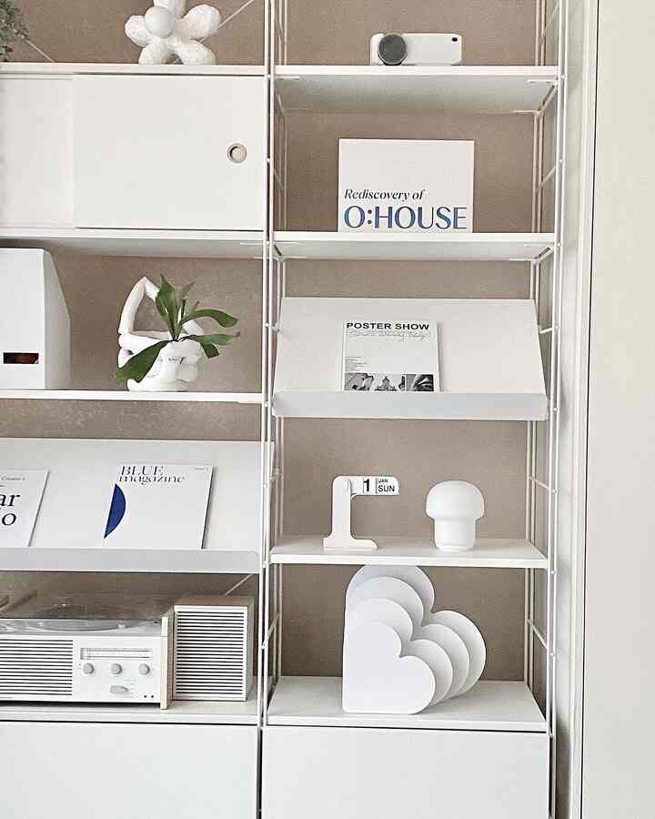 ベージュ色の壁と白い棚が調和した北欧風リビングの雰囲気あるディスプレイスペース