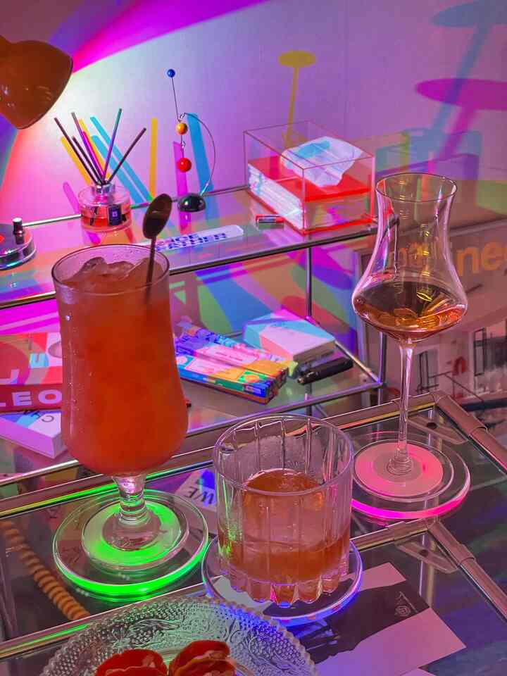 カラフルなLED照明が照らすガラスとコースターが置かれたモジュール棚のホームバー空間