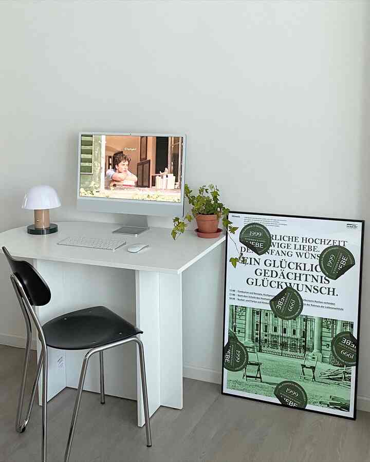 White-toned home office space featuring a white desk, black office chair, and computer, creating a clean modern atmosphere