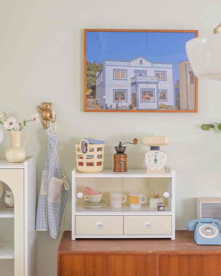 Pastel-toned kitchen featuring vintage kitchen scale, coffee grinder, and charming decorative accessories with cozy atmosphere