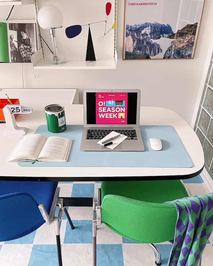 白と青のトーンのホームオフィス、きれいなデスクにMacBookとオブジェが配置された印象的な空間