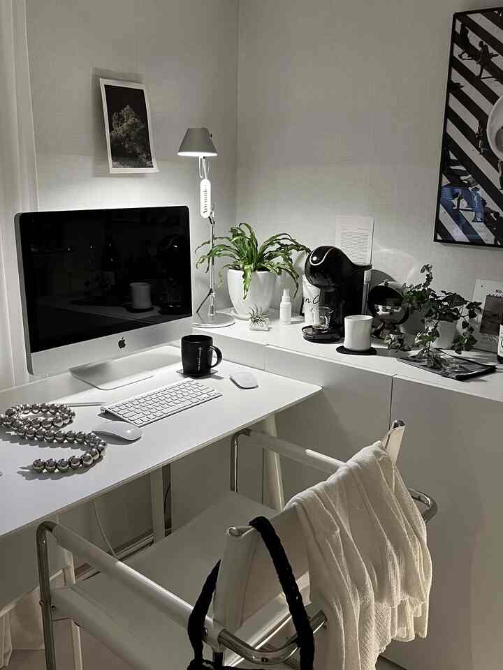 Modern home office in white tones featuring a clean desk, iMac, and coffee machine creating a cozy work environment