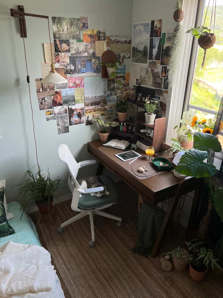 ナチュラルトーンの書斎、木製デスクと多くの植物が配置された落ち着いたホームオフィスのインテリア