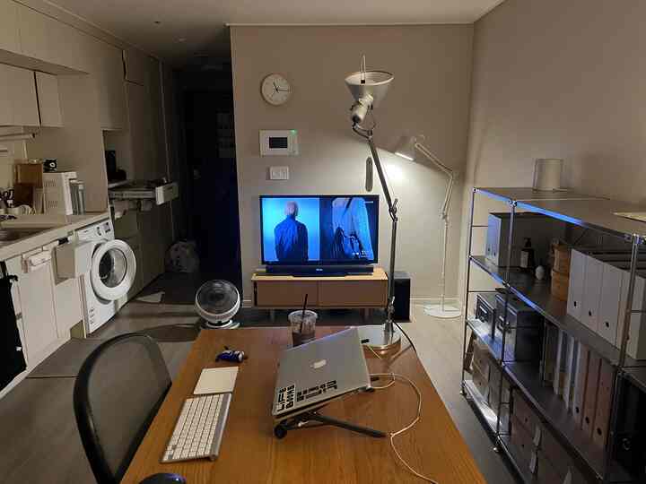 White walls and wood-tone furniture in a compact studio apartment home office space