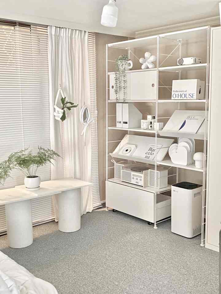 White-toned bedroom featuring shelves, curtains, and carpet arranged in a clean and natural interior
