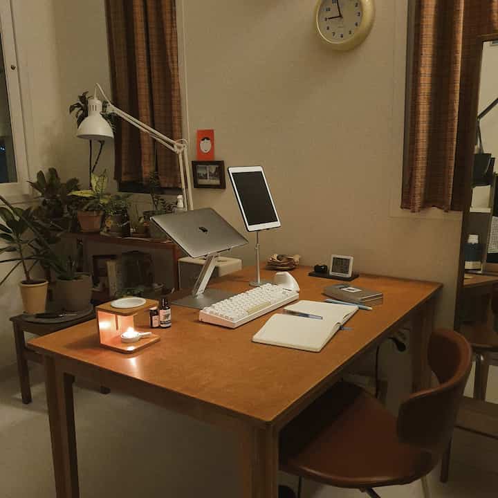 Warm wood tones and brown curtains in a home office space featuring a desk with cozy accessories and plants creating a comfortable atmosphere