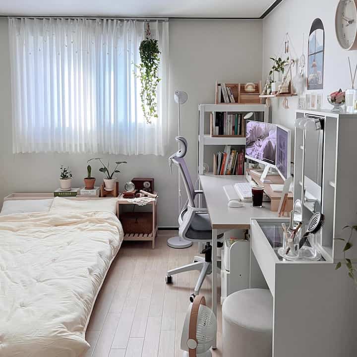 ホワイトとベージュトーンのワンルーム寝室、ナチュラルモダンなスタイルでデスクと本棚が配置された空間