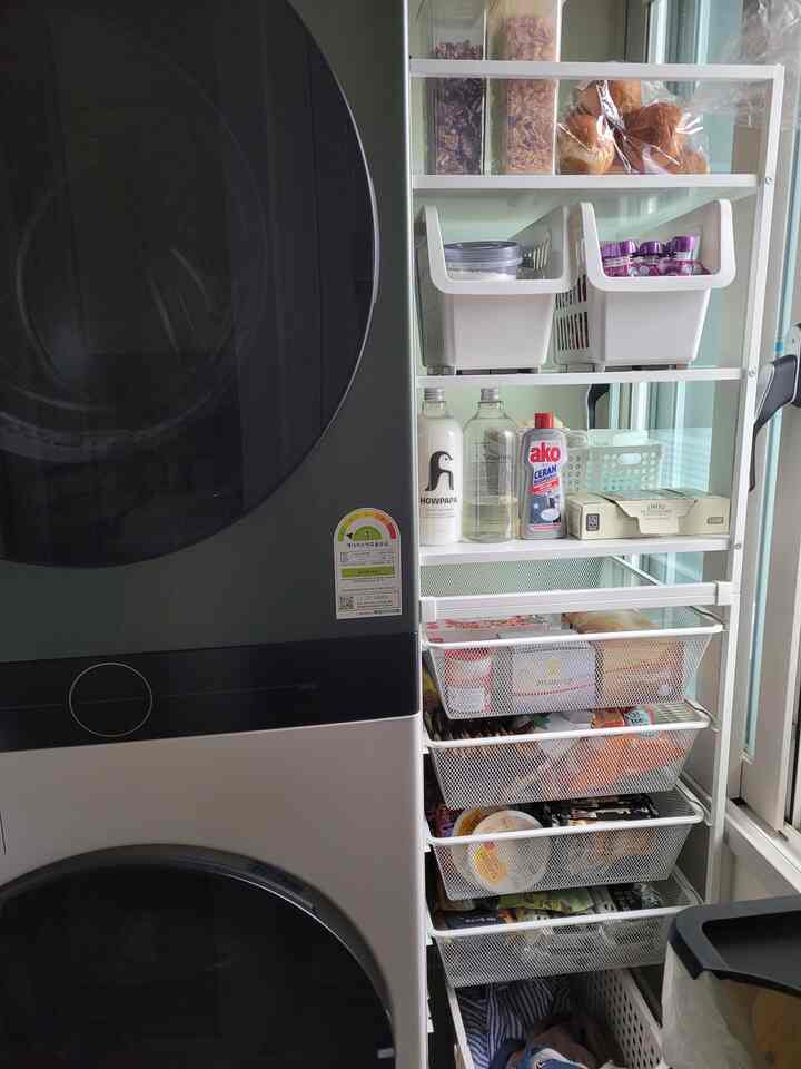 White-toned compact laundry room featuring IKEA JONAXEL shelves and LG Tromm WashTower creating an efficient tidy space