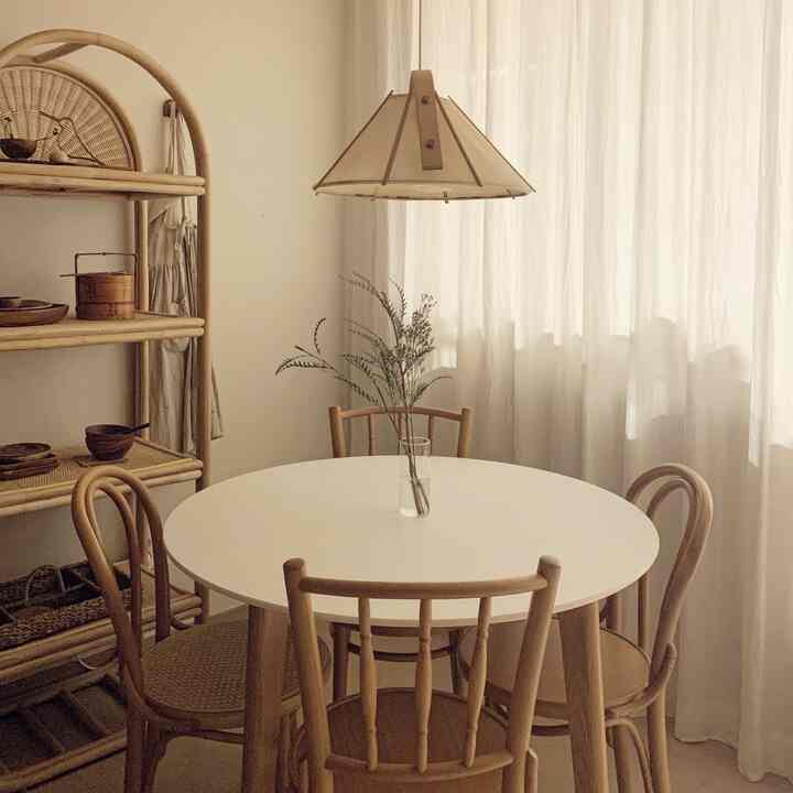 Natural wood tones and white blend in a 4-person dining room, creating a simple and cozy home cafe atmosphere