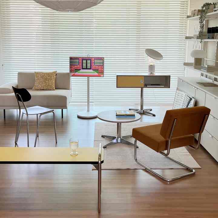 白と木目調のミッドセンチュリーモダンリビング、ラウンジチェアとベンチ、円形テーブルが配置された爽やかな空間