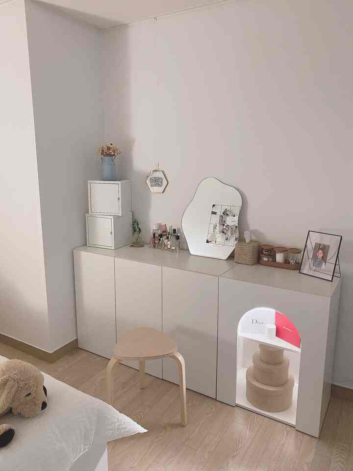 White and wood tone bedroom featuring a vanity and cabinet arranged neatly in a simple modern space