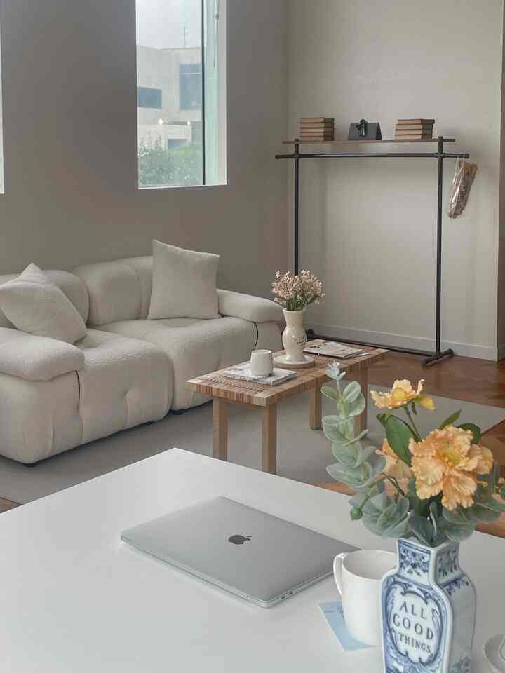 Warm beige and white toned workspace featuring ivory sofa and wooden coffee table in a cozy setting