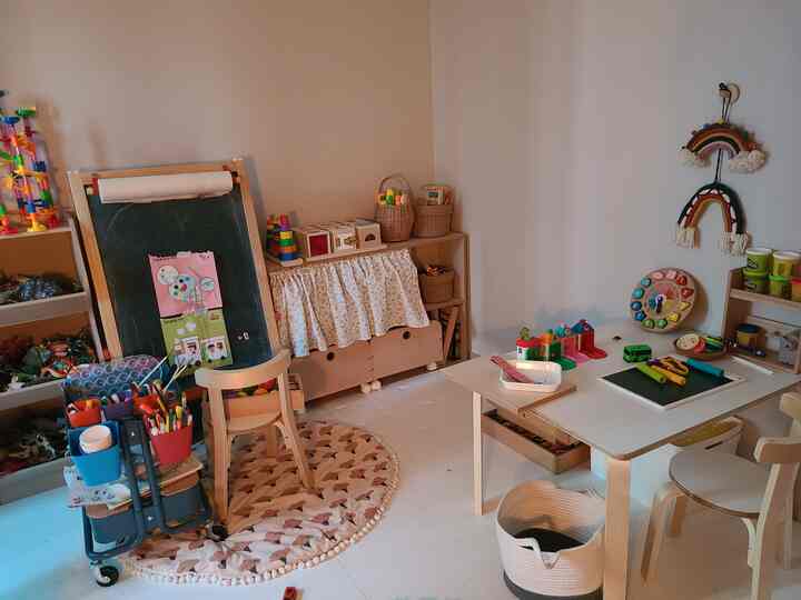 Natural and white toned kids' room featuring wooden furniture and toy storage creating a cozy learning and play area