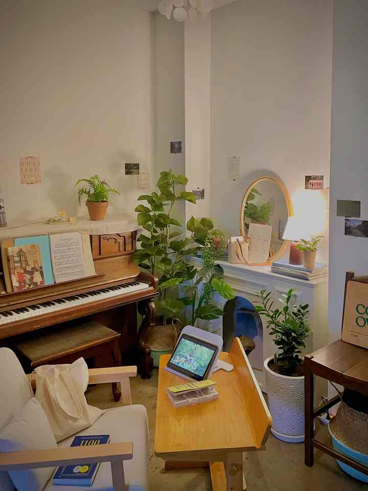 Natural wood tones and green plants blend in a cafe-style living corner, featuring cozy mood lighting and wooden dining table