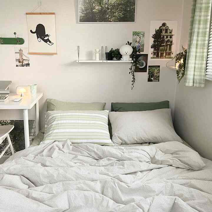 White and green toned bedroom featuring a bed and desk arranged in a cozy and natural atmosphere