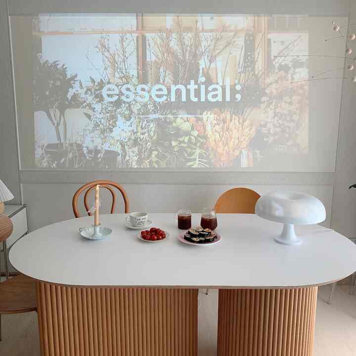White and brown toned dining room featuring a dining table, chairs, and lighting with a modern natural atmosphere