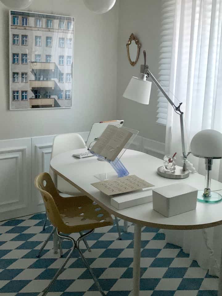 White and blue toned living room featuring wainscoting walls and oval desk, creating a modern and cozy atmosphere