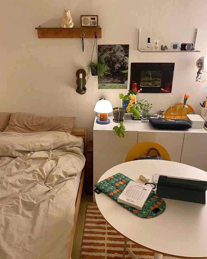 Small bedroom in white and beige tones featuring a natural wood bed and storage cabinet, creating a cozy atmosphere