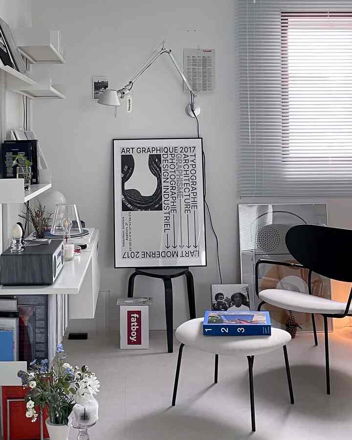 White and black toned living room featuring simple modern furniture and Artemide lighting creating a minimalist atmosphere