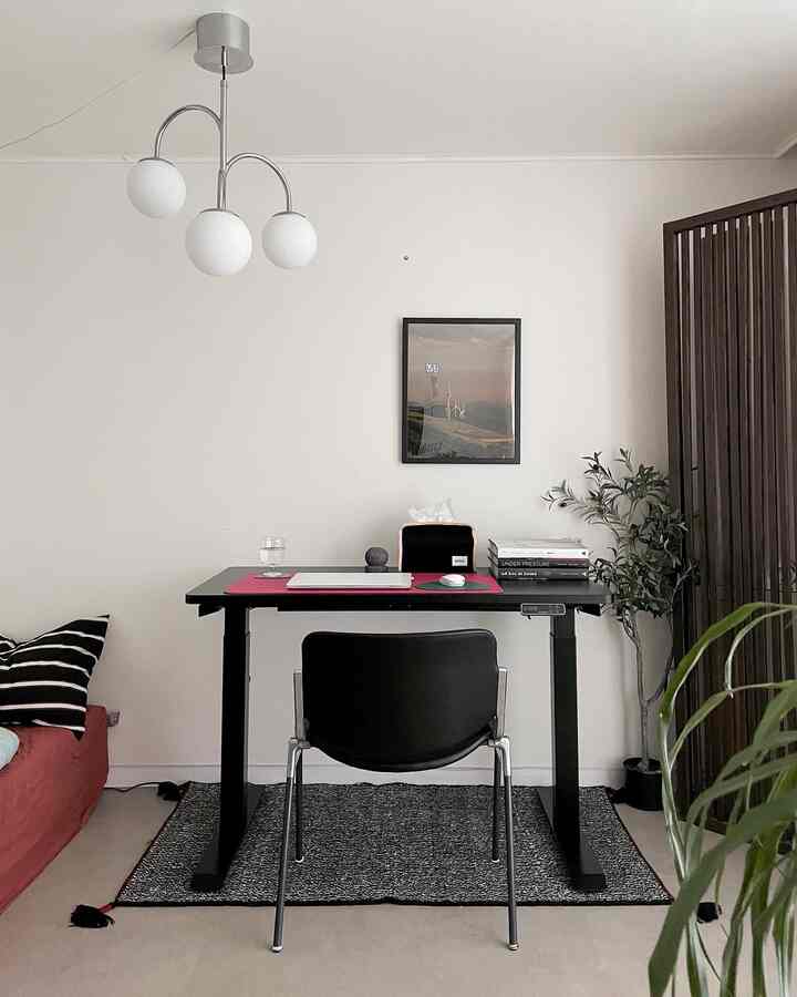 Simple modern dining room home office with white walls and black desk centerpiece