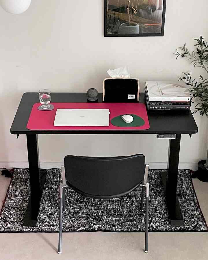 Black and gray toned home office featuring a modern desk and chair in a clean, simple workspace