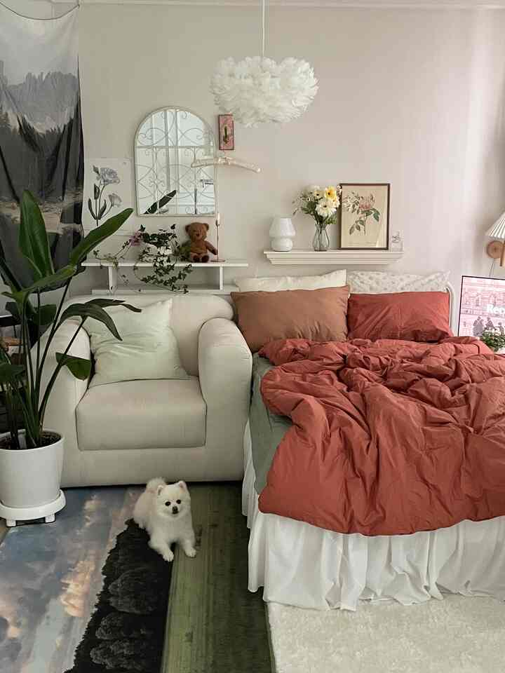 White and red toned bedroom featuring a sofa and plants, creating a cozy natural modern atmosphere