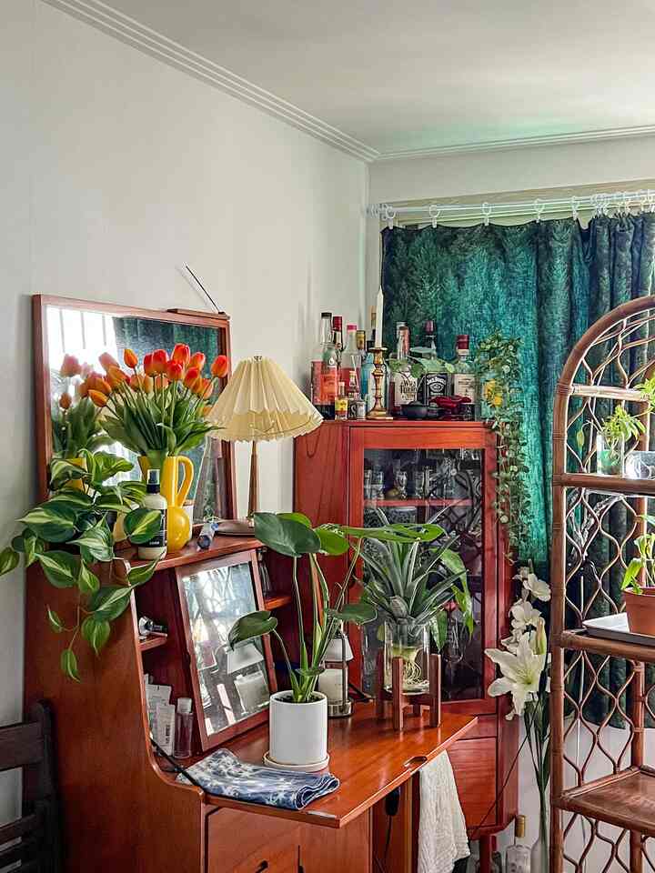 Natural wood-tone vintage living room featuring green plants and a home bar with warm lighting