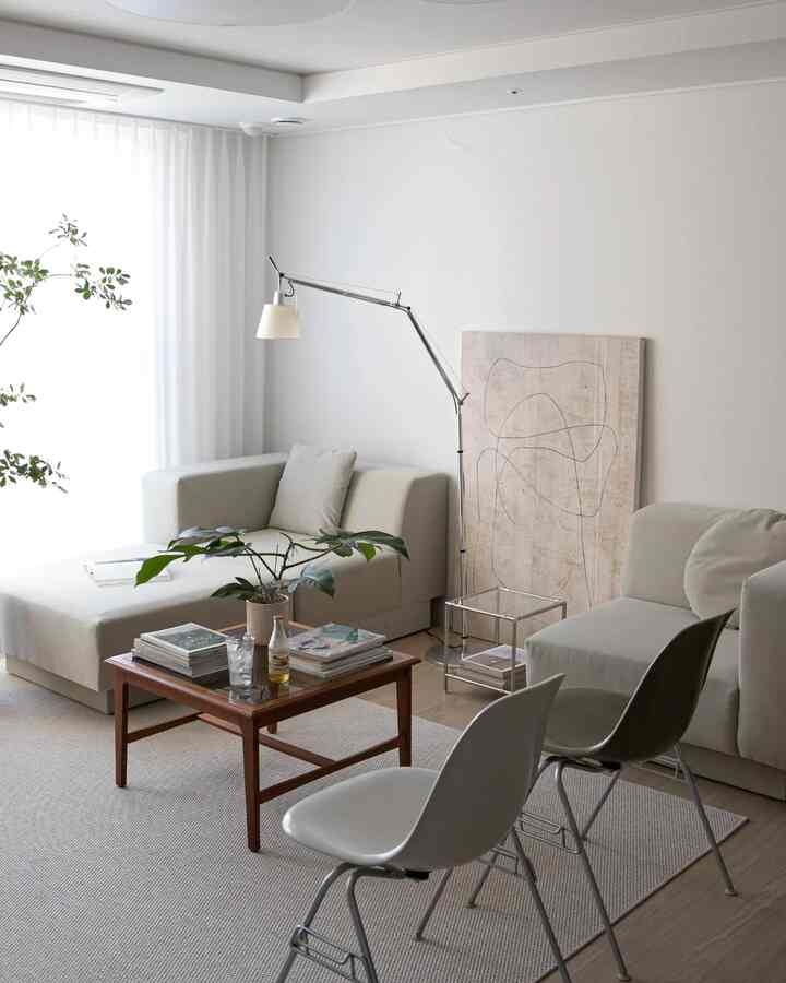 Natural beige-toned living room featuring modular sofas, a wooden coffee table, and floor lamp in a modern setting