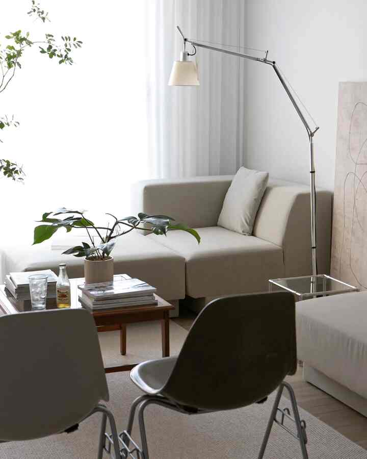 Bright white and beige dining room featuring mid-century dining chairs and a floor lamp with a natural ambiance