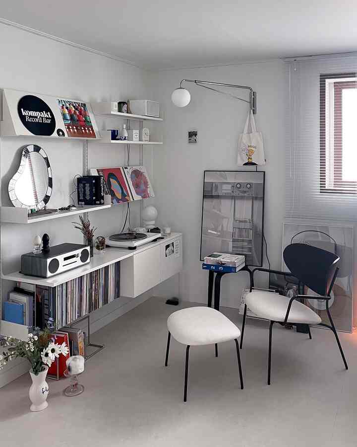 白と黒のトーンのモダンなリビング、書棚とレコードプレーヤーが配置された洗練された空間