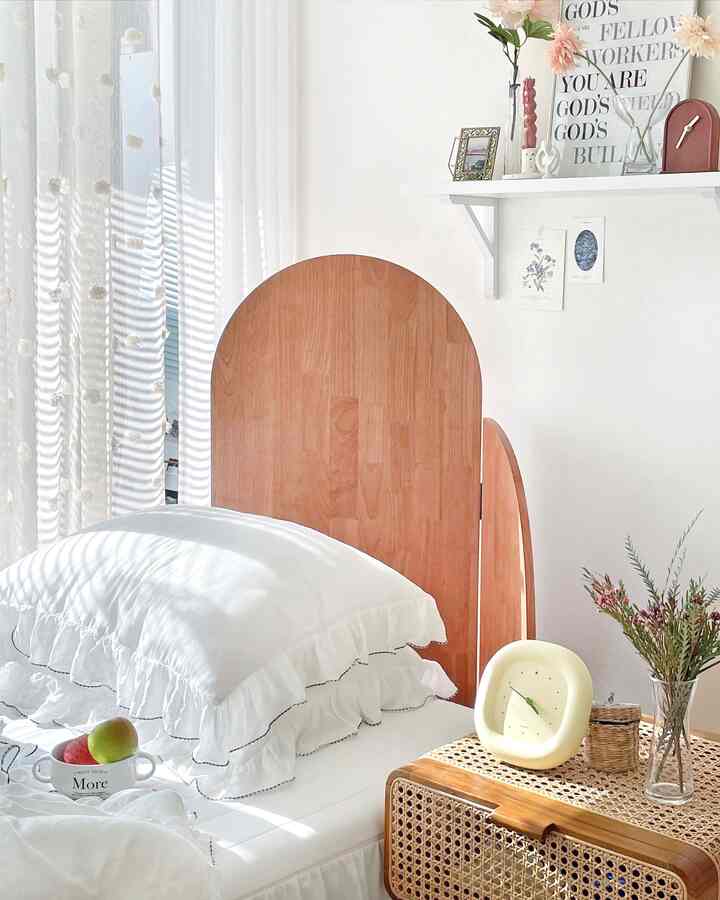 Bright white and brown natural-toned bedroom featuring an arched headboard bed and clean bedding creating a cozy atmosphere