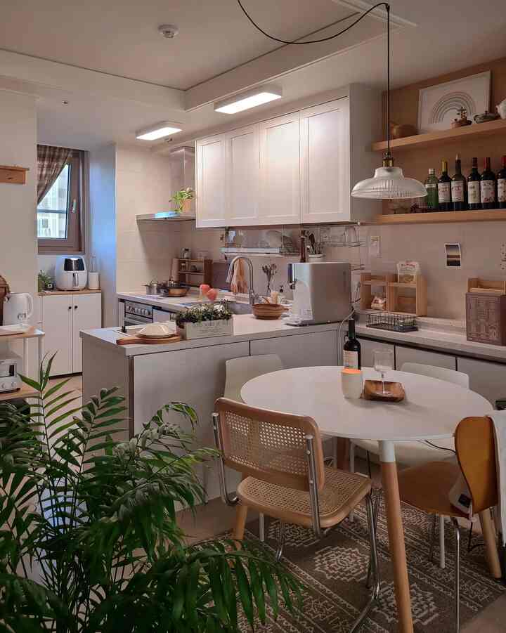 Natural brown and white toned kitchen featuring round dining table and rattan chair, creating a cozy atmosphere