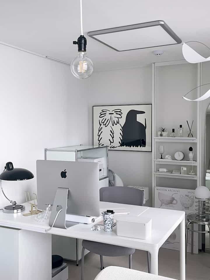 Modern white-toned study featuring a desk, office chair, and neat interior accessories in a home office setup