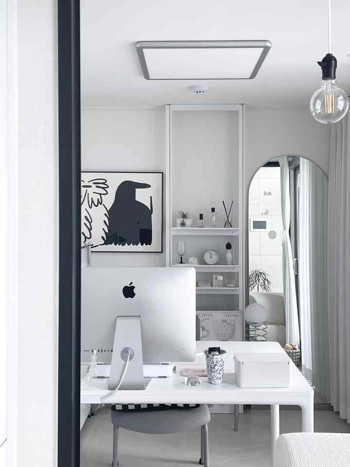 Bright white-toned home office featuring a clean desk with an iMac, modern and minimalist interior design