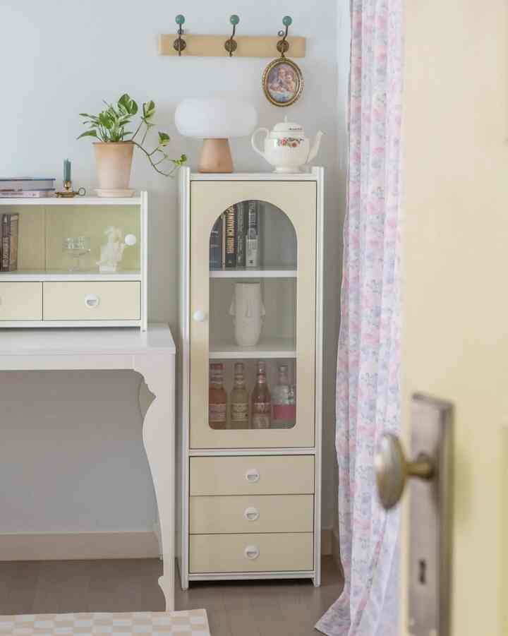Natural beige and white tones in a cozy space featuring a desk and glass-door cabinet