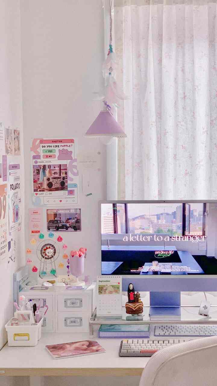 白とナチュラルカラーの一人暮らし向けホームオフィス、ピンクのアクセントと整理されたデスクが配置されたシンプルな作業空間