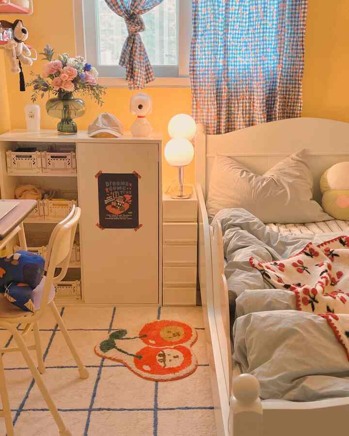 ベージュの壁と白いベッドが置かれた赤ちゃんと暮らす子供部屋、かわいいラグとカーテンが調和した温かみのあるインテリア