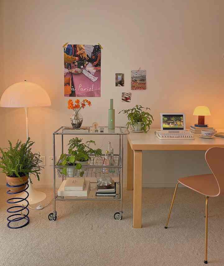 ベージュのカーペットとナチュラルカラーのホームオフィス、植物と暖かい照明が印象的な空間