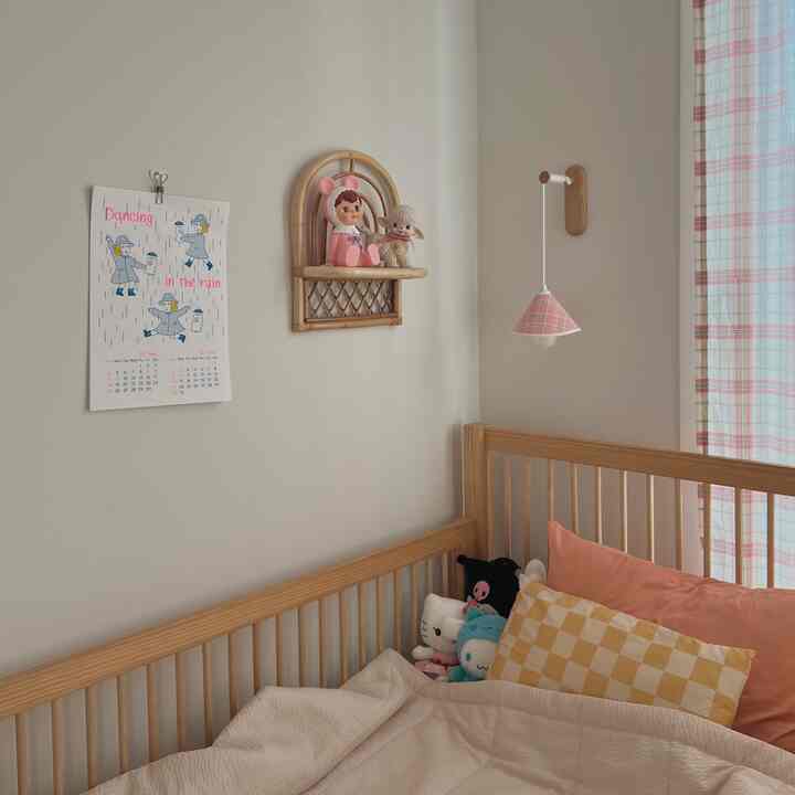 Beige walls and wood tone bed in a kids' room, featuring cute dolls and checkered curtains creating a cozy atmosphere