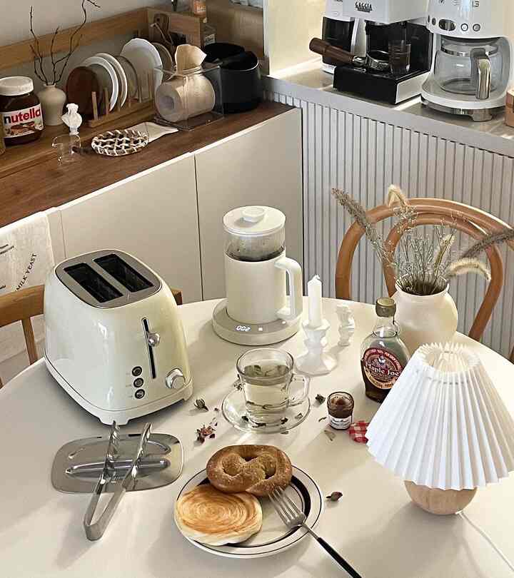 A cozy home cafe kitchen and dining table with dominant white and wood tones featuring a toaster and drip coffee set