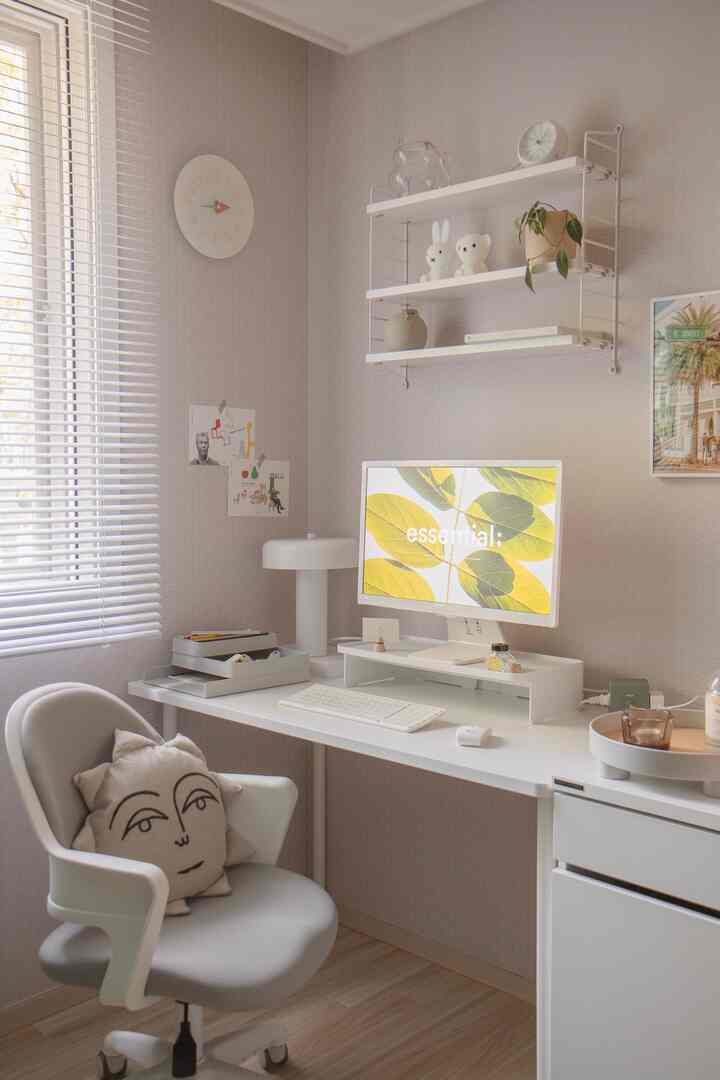 Soft white and natural-toned home office space featuring a desk, office chair, and wall shelves arranged neatly for a cozy work environment