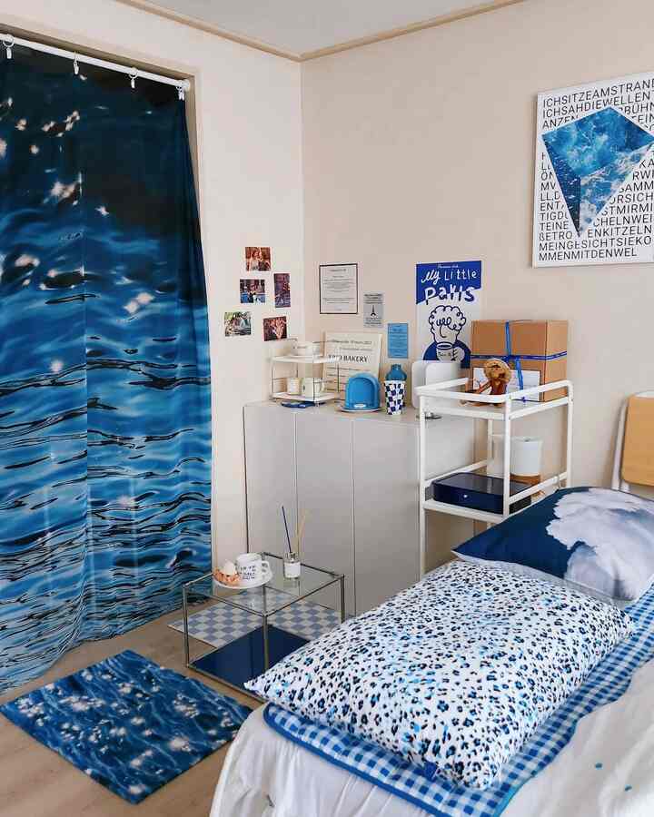 Blue-toned bedroom featuring large blue curtains and patterned bedding creating a cozy, refreshing atmosphere