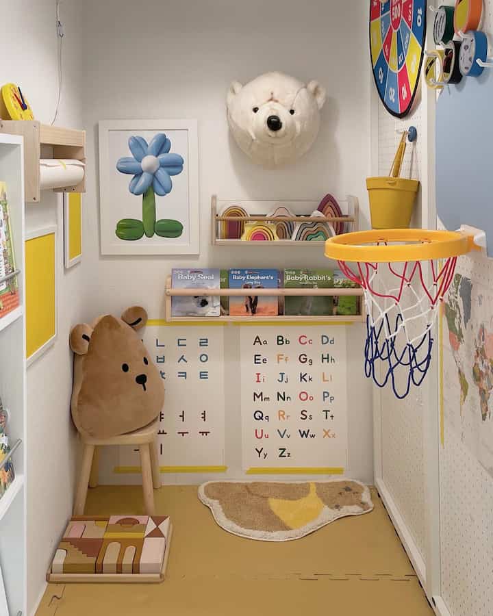 Bright white and yellow toned kids' room featuring cute bear cushions, educational books, and neatly organized toys creating a cozy play space