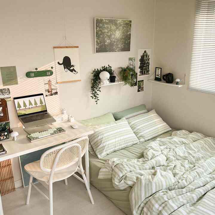 グリーンとホワイトのトーンの寝室、デスクと棚、植物が配置された温かみのあるナチュラルなインテリア