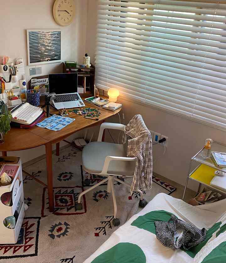A compact home office space combining white and wood tones, featuring a desk and office chair with a natural, cozy atmosphere