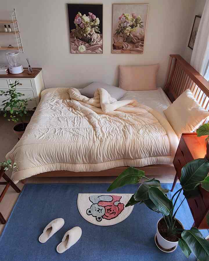 Beige and wood tone bedroom featuring a cozy bed with pillows and a blue rug, creating a warm atmosphere