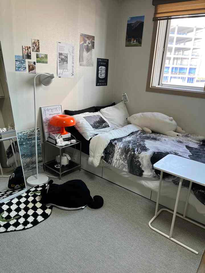 Black and white toned bedroom featuring side table and patterned rug with cozy atmosphere