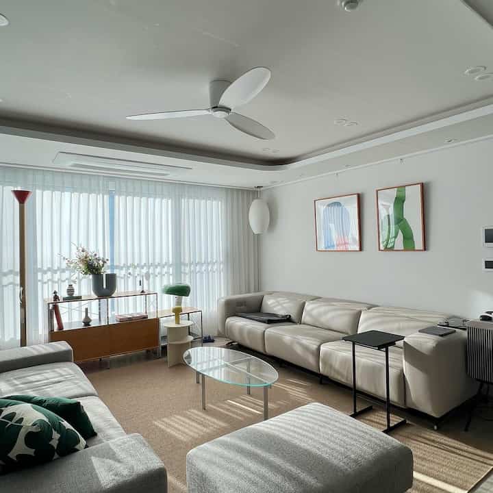 A modern living room in white and gray tones featuring Hanssem Bach 708 Goda sofa and glass coffee table