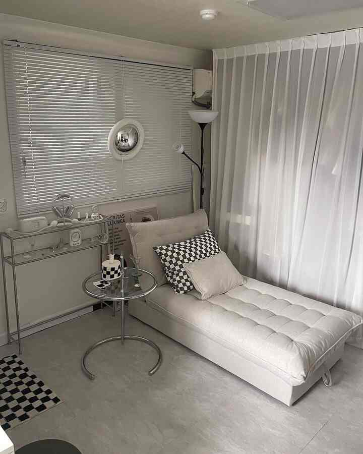 ホワイトとナチュラルカラーのリビング、ソファベッドとサイドテーブルが配置されたモダンでシンプルな印象的な空間