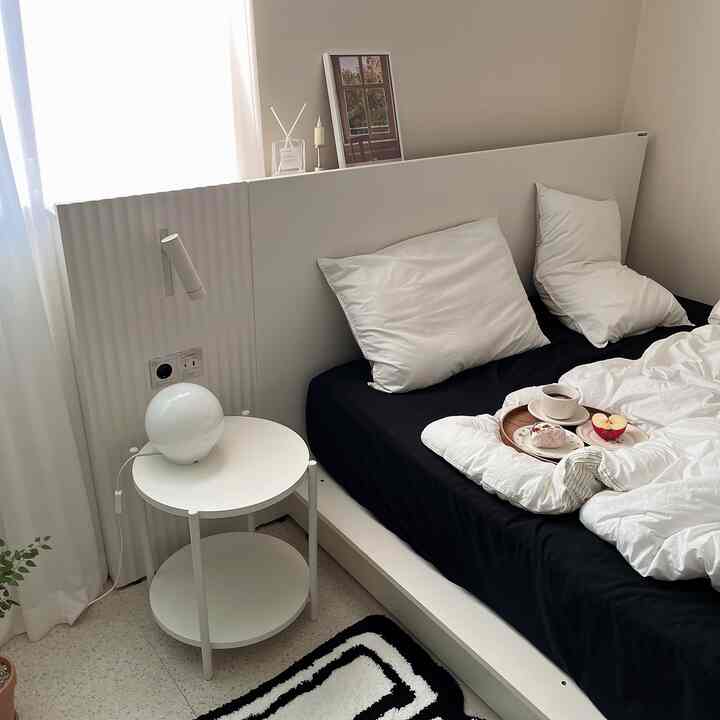 Beige and white tone bedroom featuring white bedding and black sheet, creating a clean and modern atmosphere